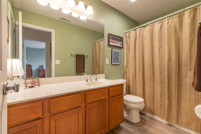 full bath with visible vents, wood finished floors, toilet, and vanity