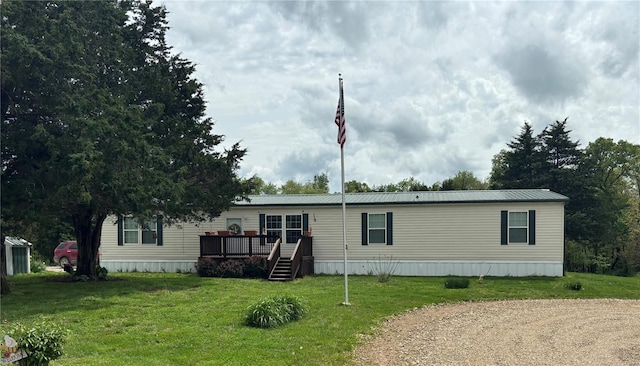 manufactured / mobile home with a front lawn and a wooden deck