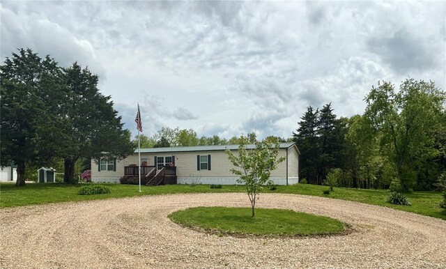 manufactured / mobile home with curved driveway and a front lawn