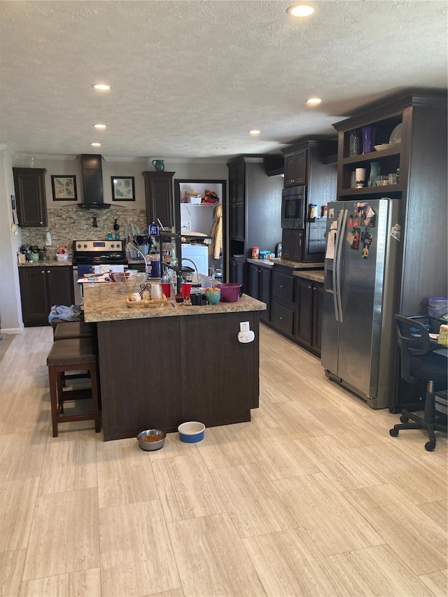 kitchen featuring wall chimney range hood, open shelves, stainless steel appliances, and a textured ceiling