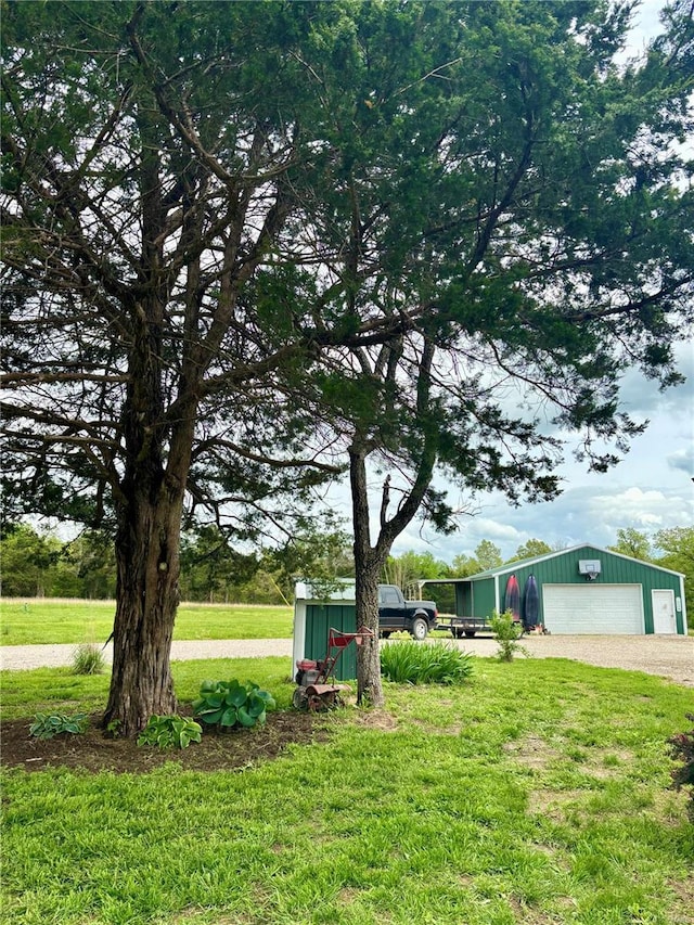 view of yard featuring an outbuilding, driveway, and a detached garage