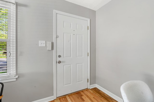 doorway to outside with baseboards and light wood-style flooring
