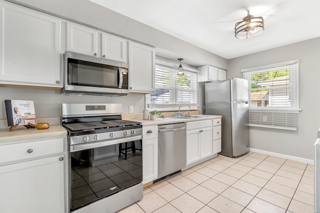 kitchen featuring light countertops, stainless steel appliances, white cabinetry, and a sink