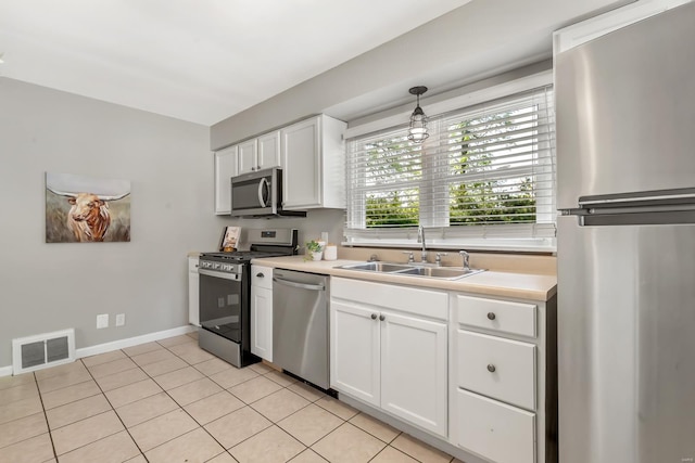 kitchen featuring a sink, appliances with stainless steel finishes, light countertops, and visible vents