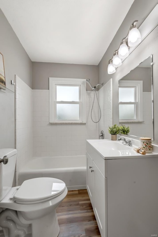 full bathroom with shower / bath combination, toilet, wood finished floors, and a wealth of natural light
