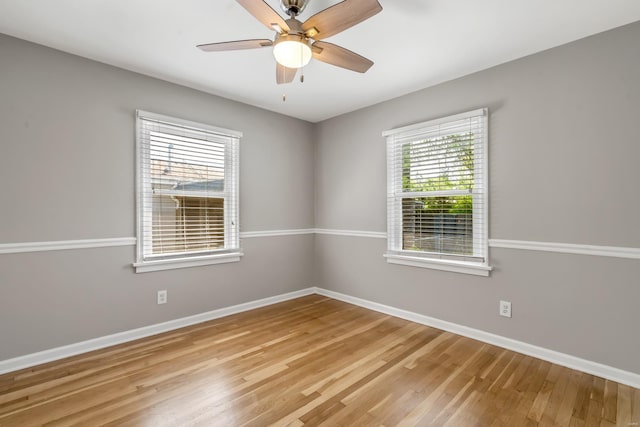 spare room with baseboards, ceiling fan, and light wood-type flooring