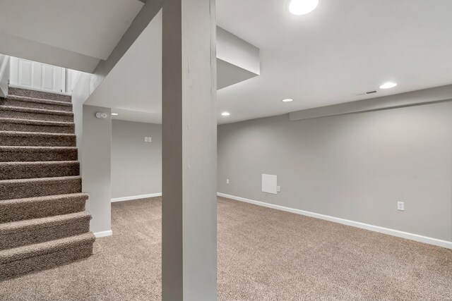 finished basement with visible vents, stairs, baseboards, recessed lighting, and carpet flooring