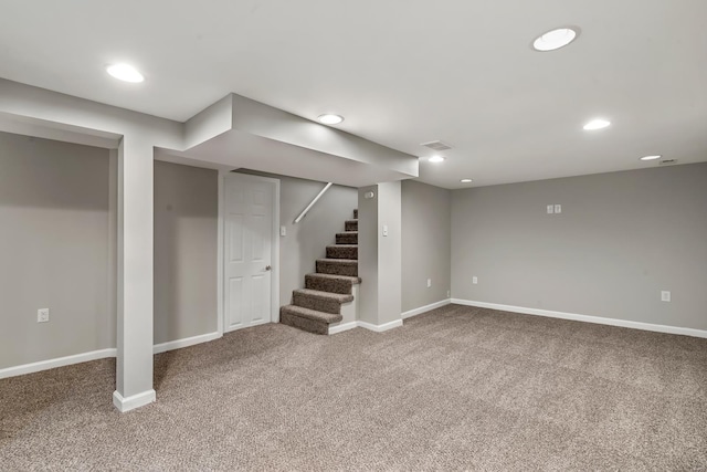finished below grade area with carpet flooring, baseboards, and stairway