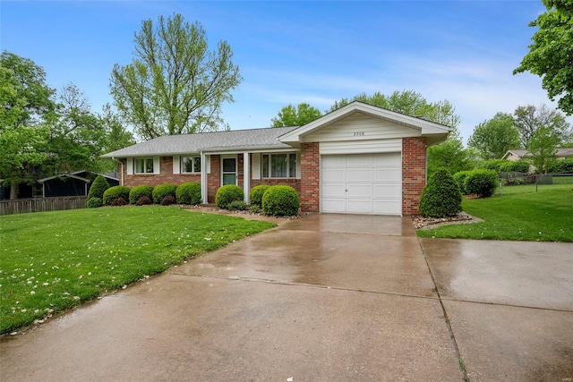 single story home featuring a garage, concrete driveway, brick siding, and a front yard