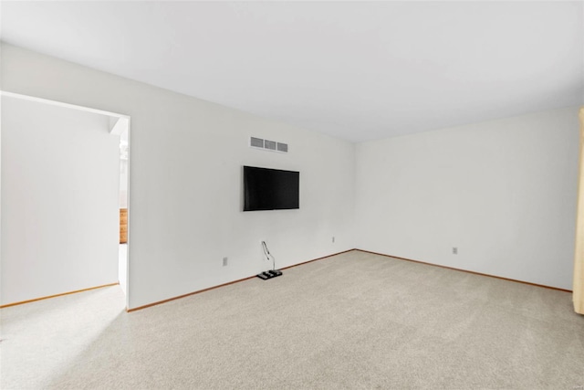 unfurnished living room featuring baseboards, visible vents, and light colored carpet