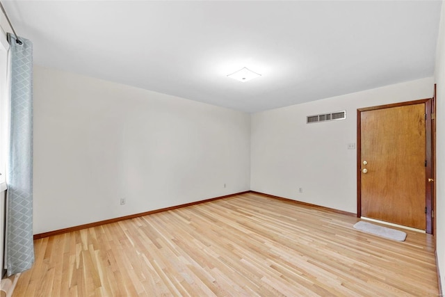 empty room featuring baseboards, visible vents, and light wood-style flooring