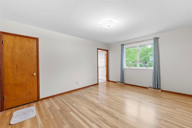 unfurnished room with baseboards, visible vents, and light wood-style floors