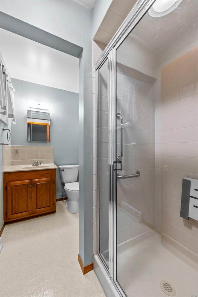 full bath with vanity, baseboards, toilet, and a shower stall