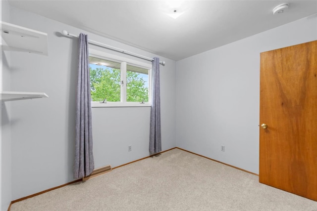 unfurnished room with baseboards and carpet
