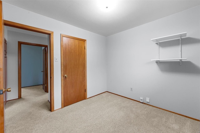 unfurnished bedroom featuring carpet flooring, baseboards, and a closet