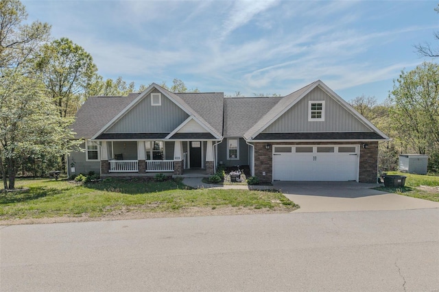 craftsman-style home with covered porch, a front lawn, concrete driveway, an attached garage, and stone siding