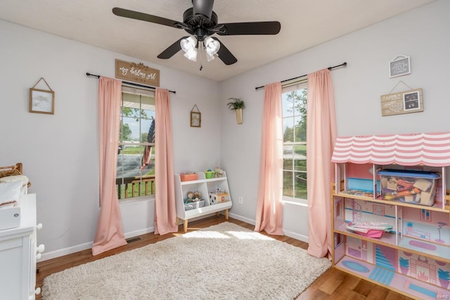 game room featuring baseboards, ceiling fan, and wood finished floors