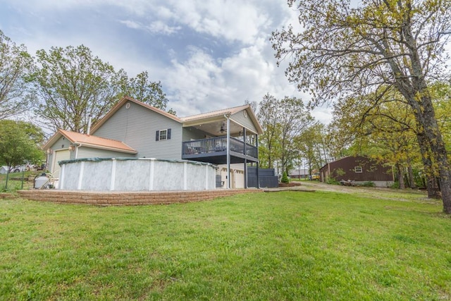 back of house with a yard, a ceiling fan, a balcony, and a garage