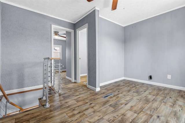 spare room featuring crown molding, ceiling fan, wood finished floors, and visible vents