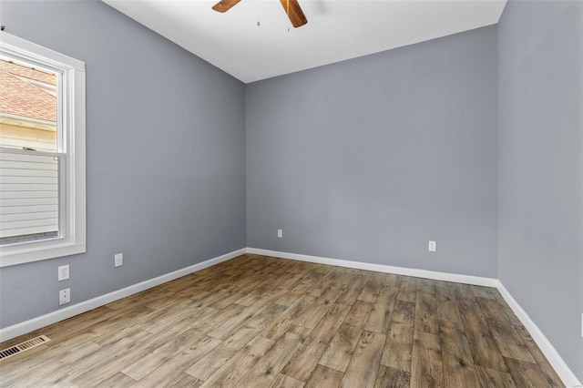unfurnished room with a ceiling fan, baseboards, visible vents, and wood finished floors