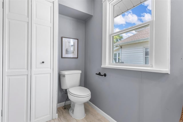 bathroom featuring baseboards and toilet