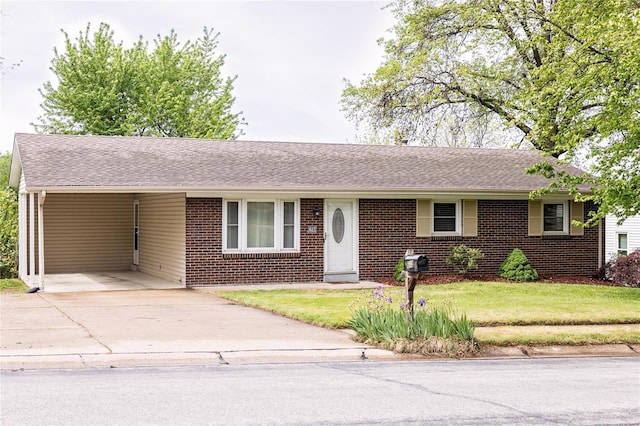 single story home with brick siding, an attached carport, a front yard, and concrete driveway