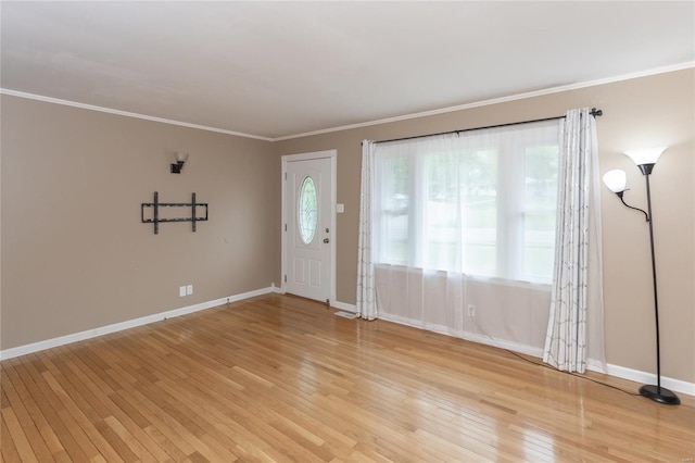 entryway with baseboards, ornamental molding, and light wood-type flooring