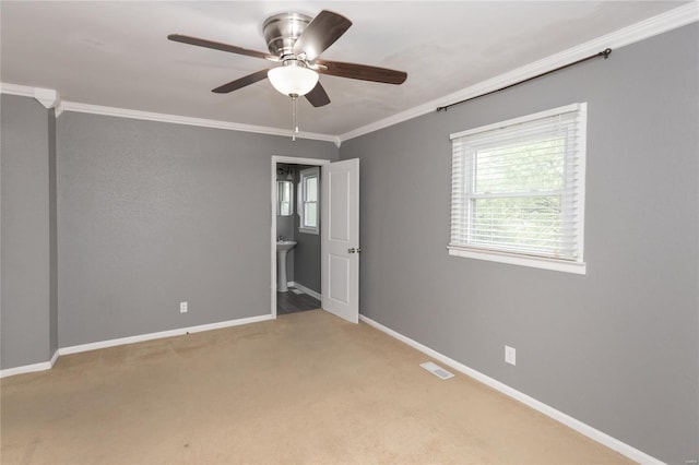 carpeted empty room with crown molding, a ceiling fan, baseboards, and visible vents