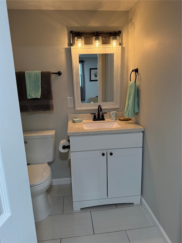 bathroom featuring vanity, tile patterned flooring, baseboards, and toilet