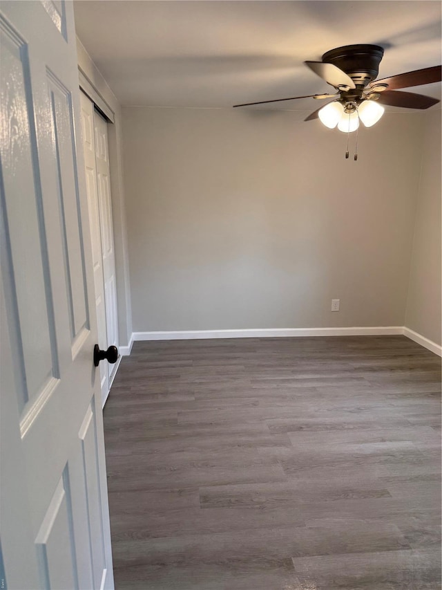 unfurnished bedroom featuring baseboards, ceiling fan, and dark wood-style flooring