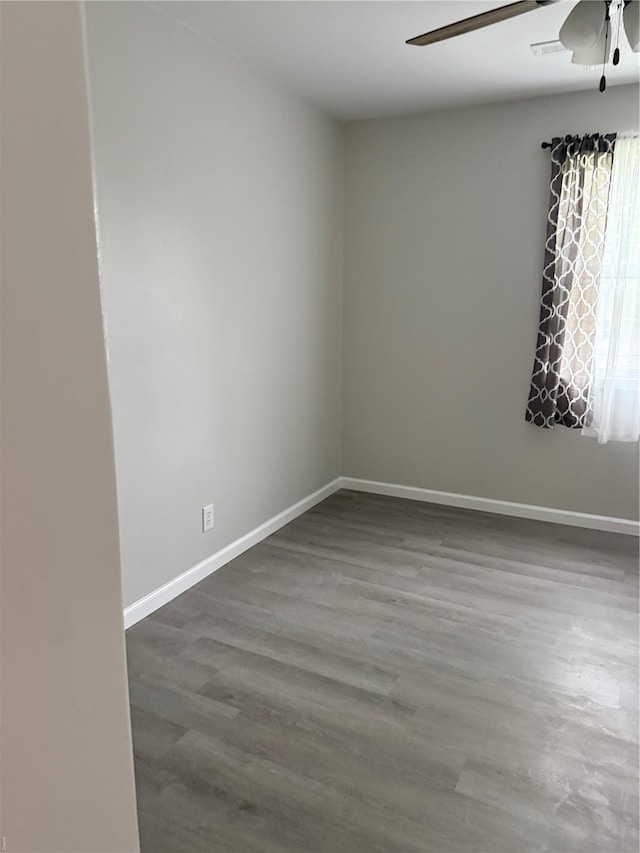 empty room featuring baseboards, ceiling fan, and wood finished floors