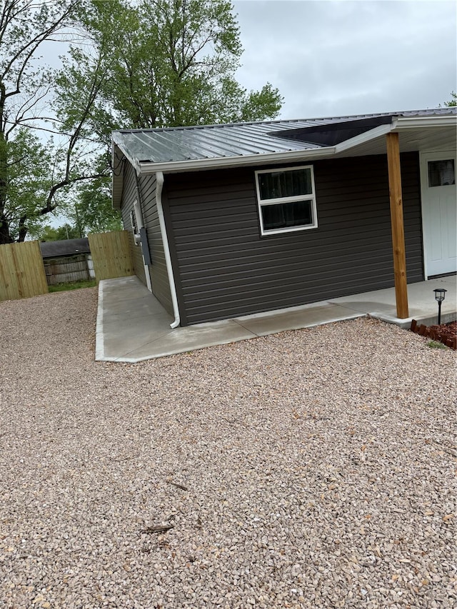 view of side of property with a patio and fence