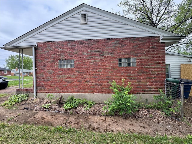 view of side of home featuring brick siding and cooling unit