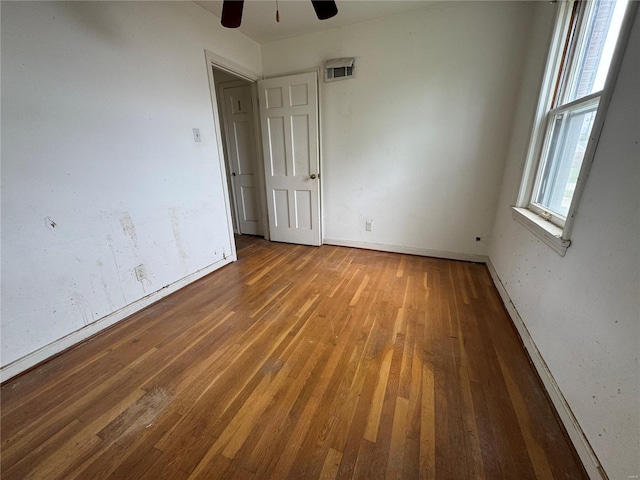 unfurnished bedroom with visible vents, a ceiling fan, baseboards, and wood finished floors