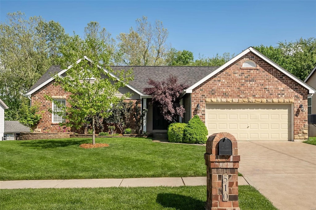 ranch-style house with an attached garage, concrete driveway, a front lawn, and brick siding