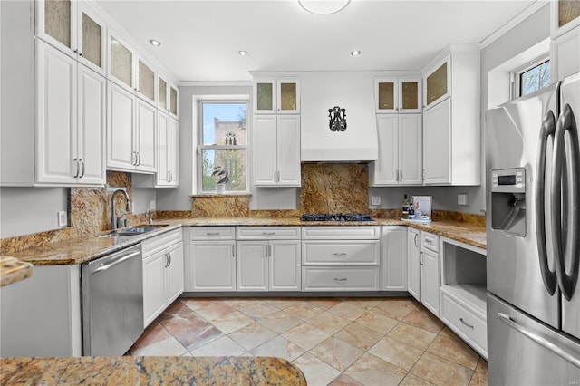 kitchen featuring stainless steel appliances, ornamental molding, a sink, and plenty of natural light