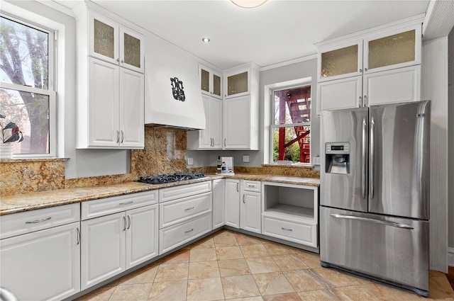 kitchen featuring stainless steel fridge, white cabinetry, backsplash, and black gas cooktop