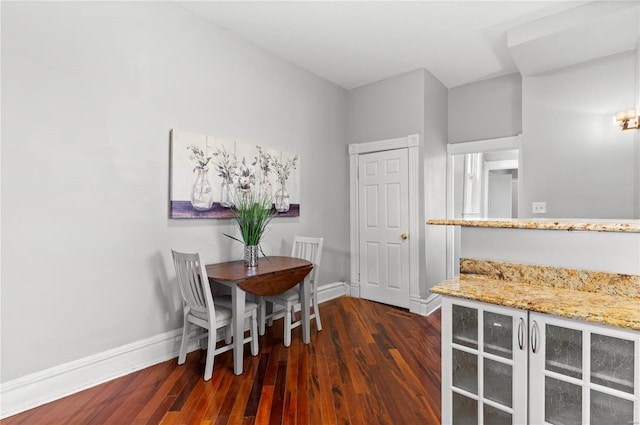 dining room featuring dark wood-style flooring and baseboards