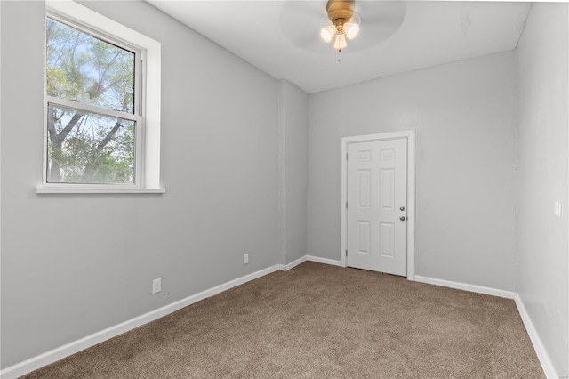 spare room with carpet floors, ceiling fan, and baseboards