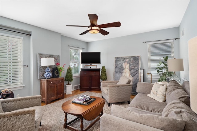 living area featuring ceiling fan, visible vents, and wood finished floors