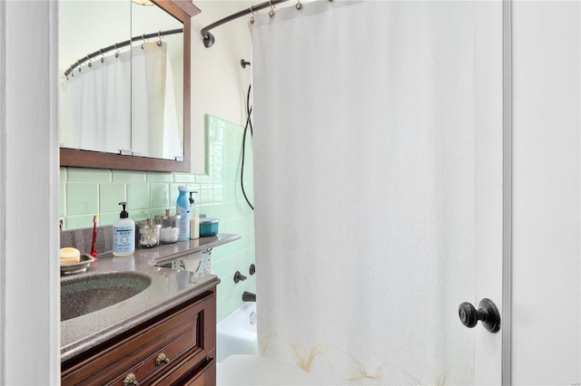 bathroom featuring vanity, decorative backsplash, and shower / bath combo with shower curtain