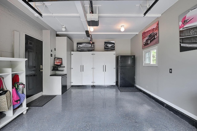 garage featuring baseboards, a garage door opener, and freestanding refrigerator