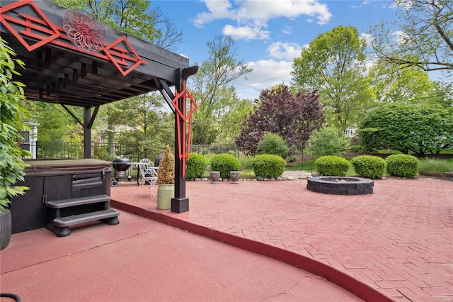 view of patio / terrace featuring a hot tub and a fire pit