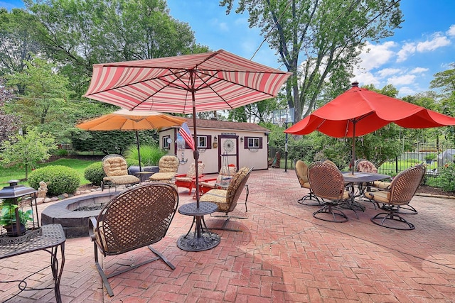 view of patio featuring fence, an outdoor structure, and a fire pit
