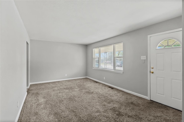 carpeted entrance foyer featuring baseboards and plenty of natural light