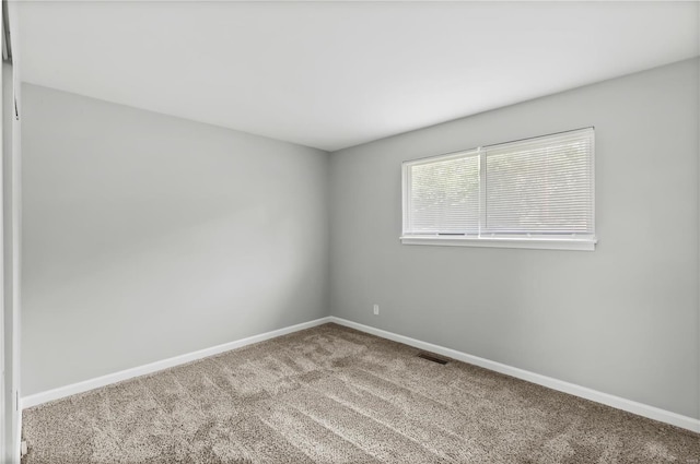 carpeted spare room with baseboards and visible vents