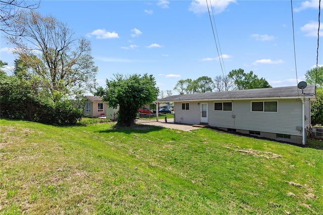 back of house with a lawn and a patio