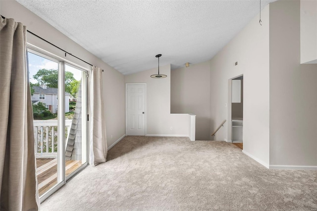 spare room with carpet floors, a textured ceiling, vaulted ceiling, and baseboards