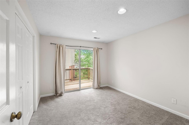 carpeted spare room with visible vents, recessed lighting, a textured ceiling, and baseboards