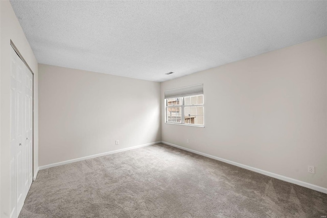 unfurnished bedroom featuring a closet, baseboards, carpet flooring, and a textured ceiling
